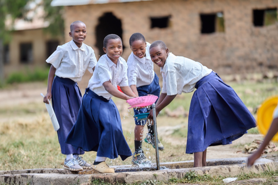 Children at Idugumbi Primary School, Mbeya, Tanzania, wash their plates after having lunch. Credit: GPE/Mrutu (Trans.Lieu)